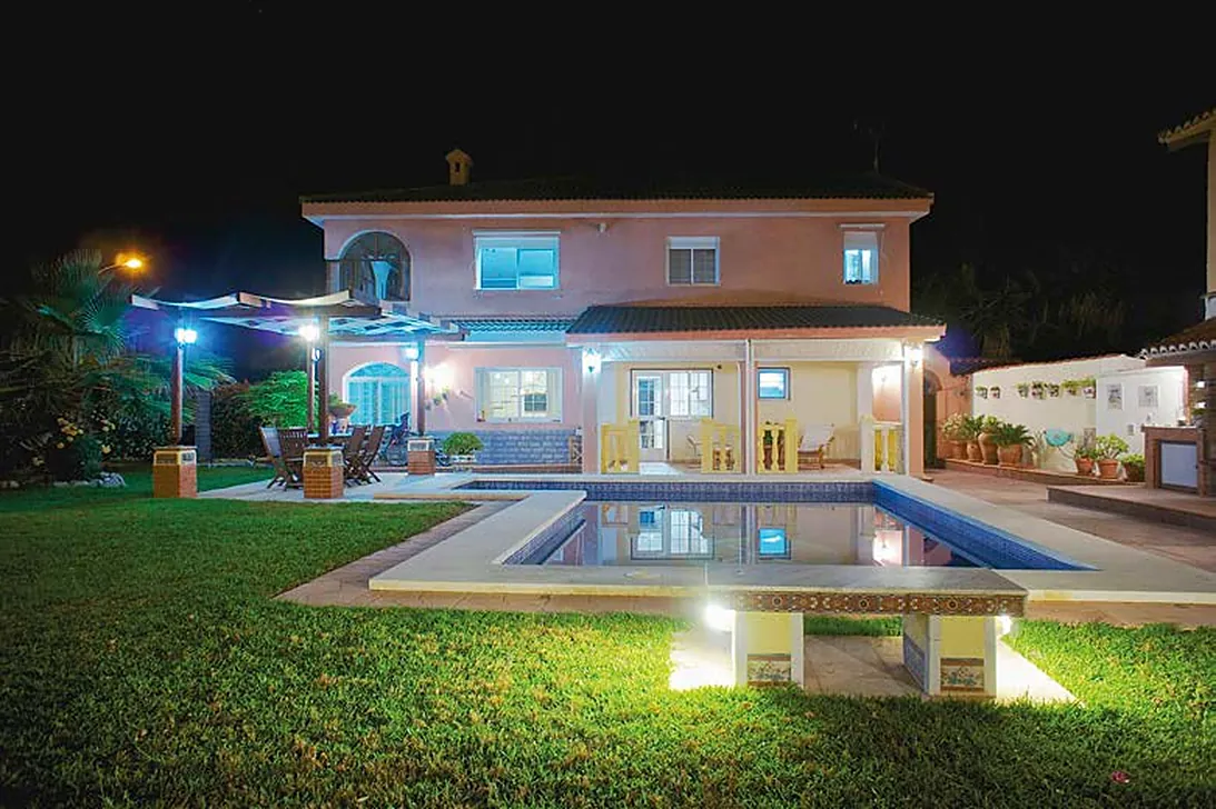 Fotografía nocturna profesional de un chalet con piscina